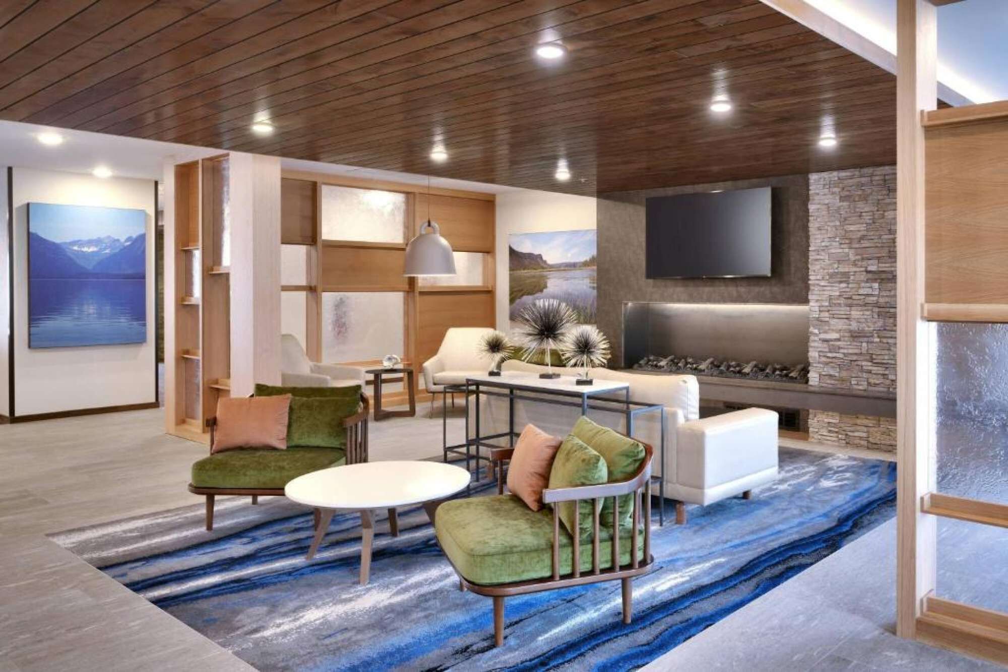 A modern living room with a fireplace, seating area, and artwork on the walls.