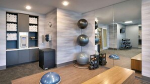Een moderne hotel lobby met een receptiebalie, een hangend horloge en een schoenenrek.