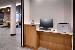 Un espacio de oficina moderno con escritorio, computadora e impresora.