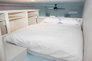 A bedroom with a bed, a ceiling fan, and a white wardrobe. - Casa Dora Summer Waves (Bolivar Peninsula)