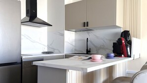 A modern kitchen with a built-in island, stainless steel appliances, and a marble backsplash. - PINTOR SOROLLA elegant apartment (Benidorm)