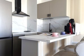 A modern kitchen with a built-in island, stainless steel appliances, and a marble backsplash. - PINTOR SOROLLA elegant apartment (Benidorm)