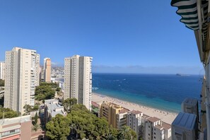Eine Küstenstadt mit hoch aufragenden Gebäuden, einem Strand und einem klaren Himmel.