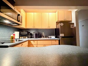 A kitchen with wooden cabinets, a microwave, a toaster, a coffee maker, and a refrigerator. - Remote Quiet Location Amazing Culebra Views (Ceiba)