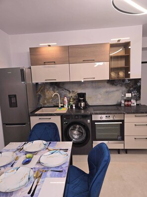 A compact kitchen with a built-in washer, oven, and coffee maker.