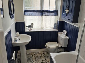 A bathroom with a window, a sink, a toilet, and a bathtub. - Twisted Chimney View (Alford)