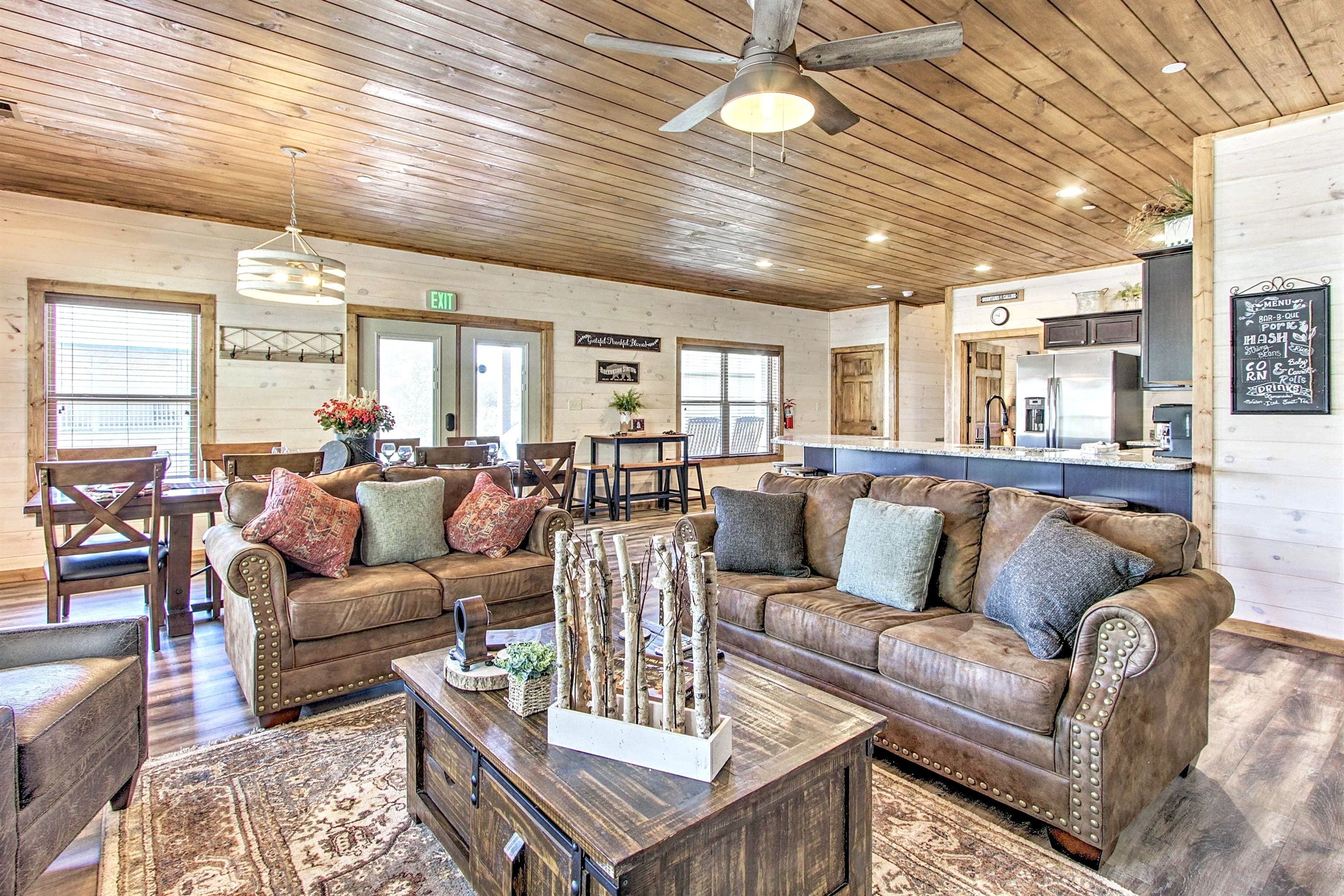 A cozy interior with wooden ceilings, a bar area, and a seating area with couches and a coffee table.