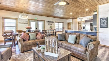 A cozy interior with wooden ceilings, a bar area, and a seating area with couches and a coffee table.