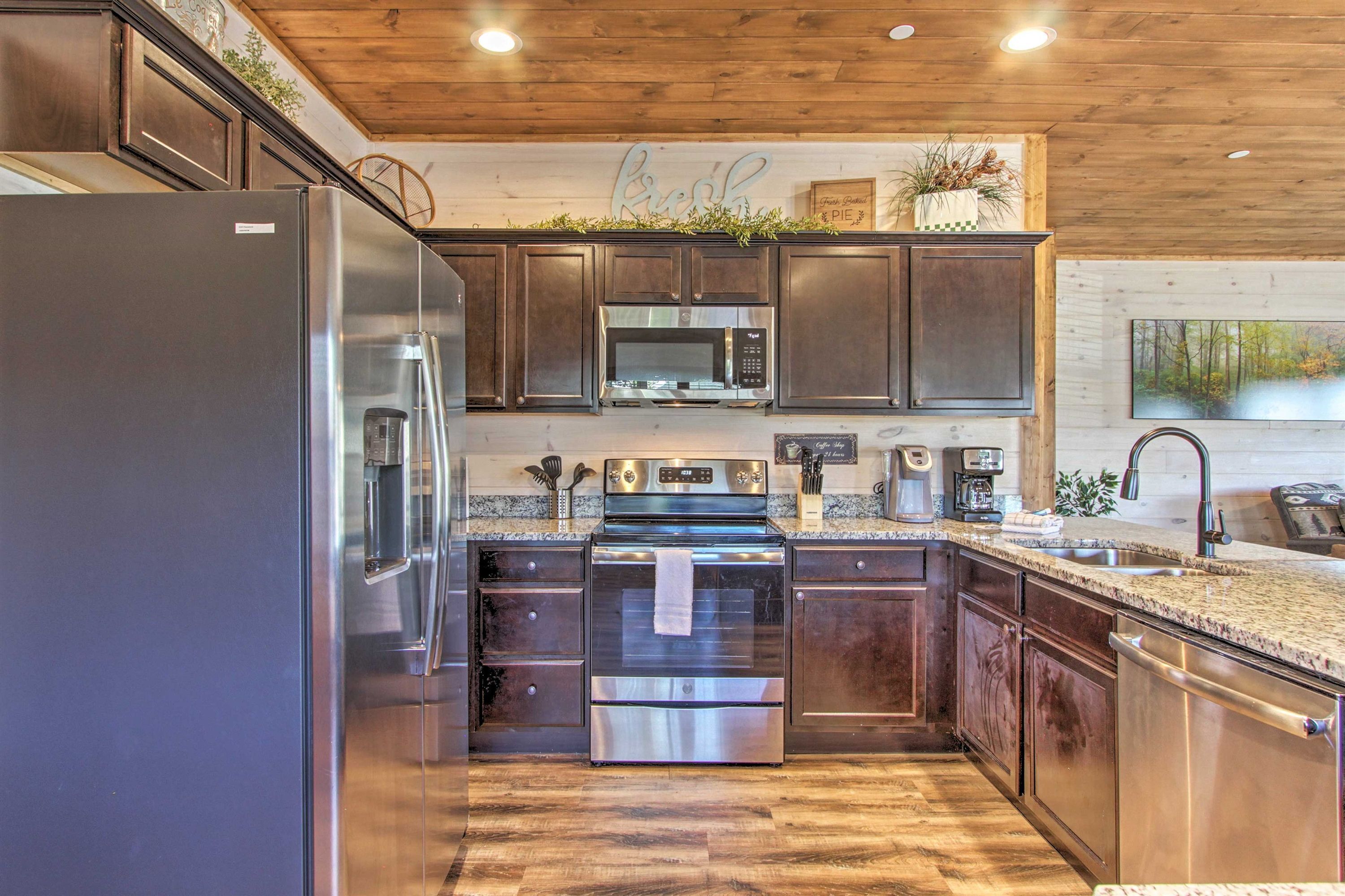 A modern kitchen with stainless steel appliances, wooden cabinets, and a granite countertop.