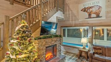 Ein Holzinnenraum mit Kamin, Weihnachtsbaum, Treppe und Bären-Wandbild.