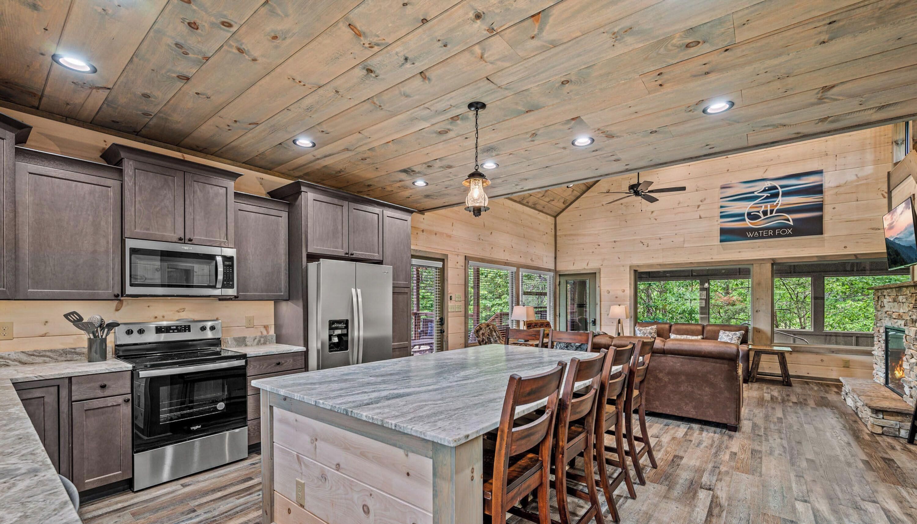 A spacious kitchen with modern appliances, a large island, and a dining area with a stone fireplace.
