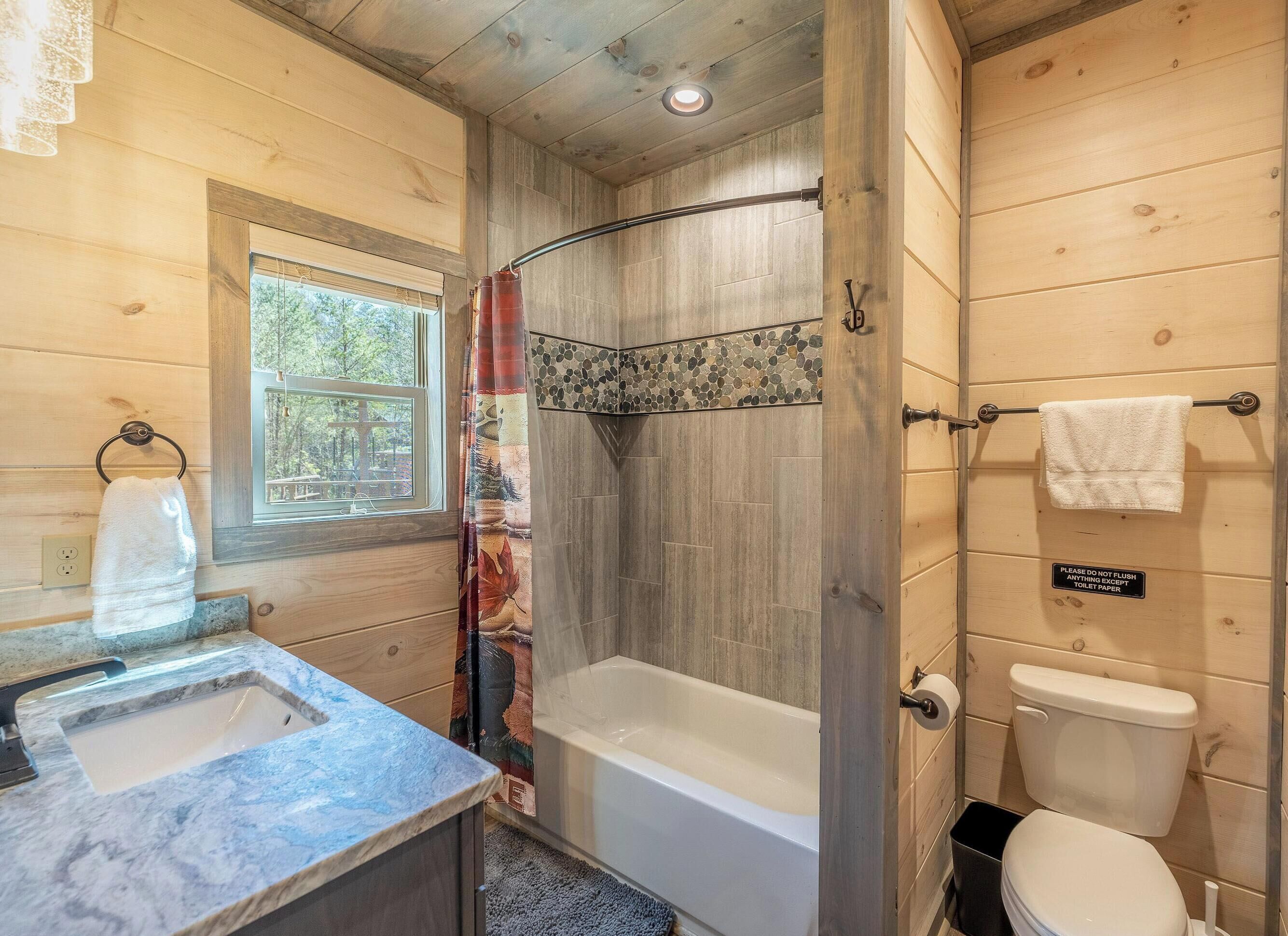 A bathroom with a bathtub, toilet, and sink.