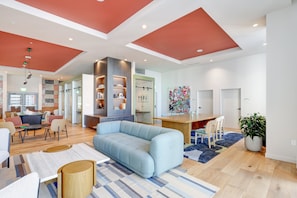 A spacious living area with a light blue sofa, wooden flooring, and a modern kitchen in the background. - The Crosby Luxury 1BR/1BA in Downtown Miami | 710 (Miami)