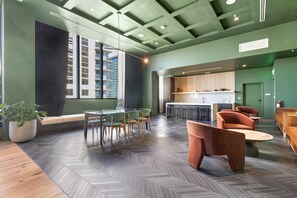 A modern interior with a herringbone floor pattern, a dining area with a round table and chairs, and a kitchen area with a bar counter. - The Crosby Luxury 1BR/1BA in Downtown Miami | 710 (Miami)