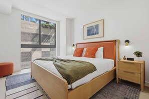 A modern bedroom with a bed, bedside tables, a nightstand, a framed picture, and a window. - The Crosby Luxury 1BR/1BA in Downtown Miami | 710 (Miami)