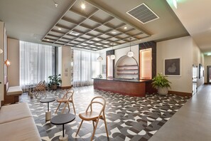 A hotel lobby with a reception desk, seating area, and large windows. - The Crosby Luxury 1BR/1BA in Downtown Miami | 710 (Miami)