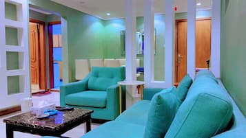 A modern living room with teal sofas, a coffee table, and a small side table.