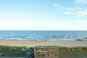 A beach with a wooden structure, possibly a gazebo, near the water. - Casa Dora Beachfront Loft (Bolivar Peninsula)