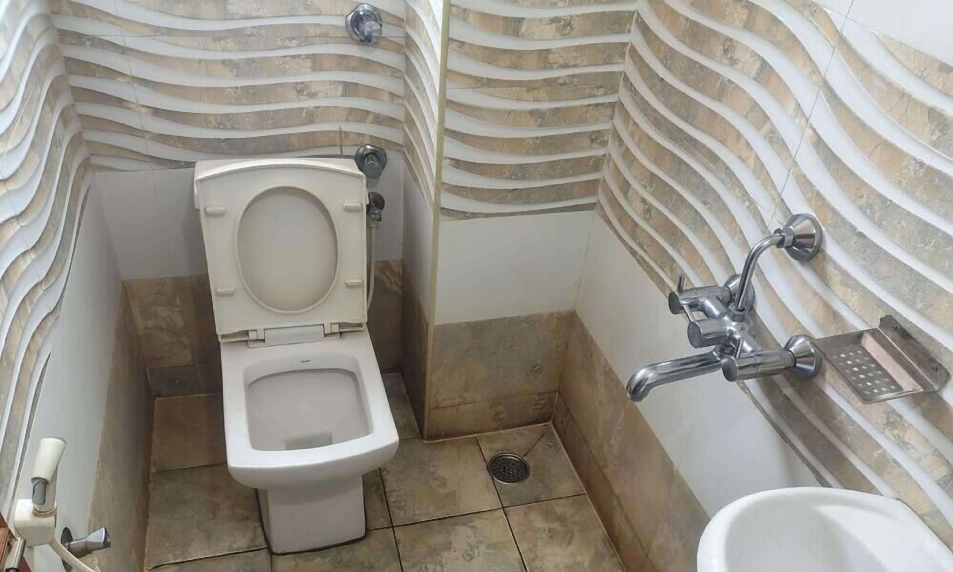 A small bathroom with a toilet, a shower, and a sink.