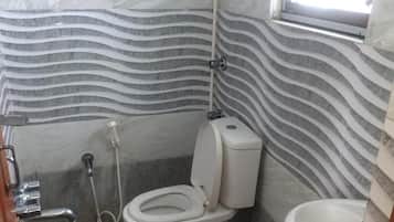 A bathroom with a toilet, bidet, and sink.