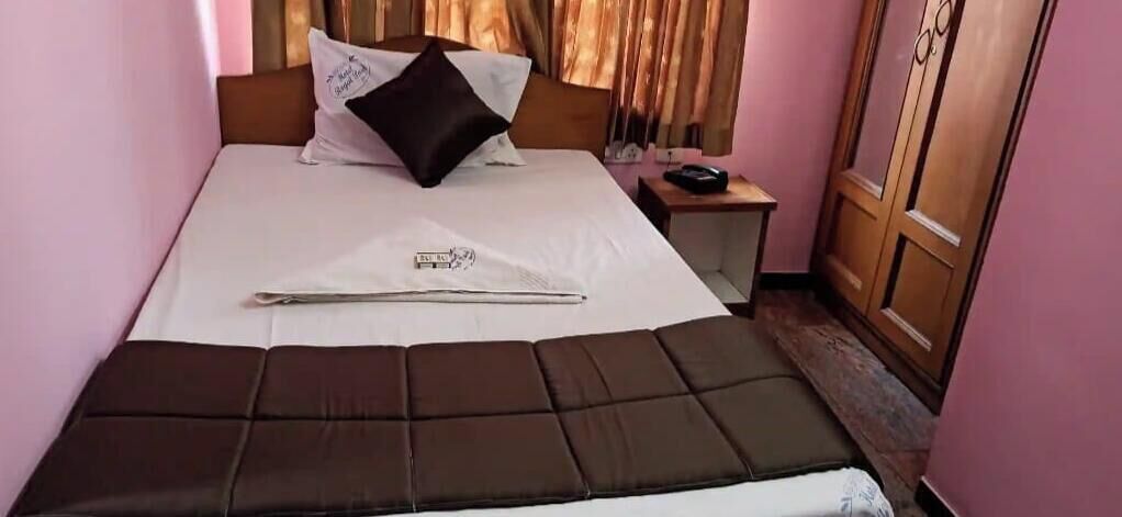 A bed with a headboard, a bedside table with a lamp, and a wardrobe.