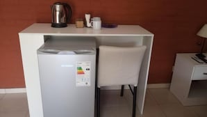 A kitchenette with a refrigerator, a coffee maker, and a microwave.