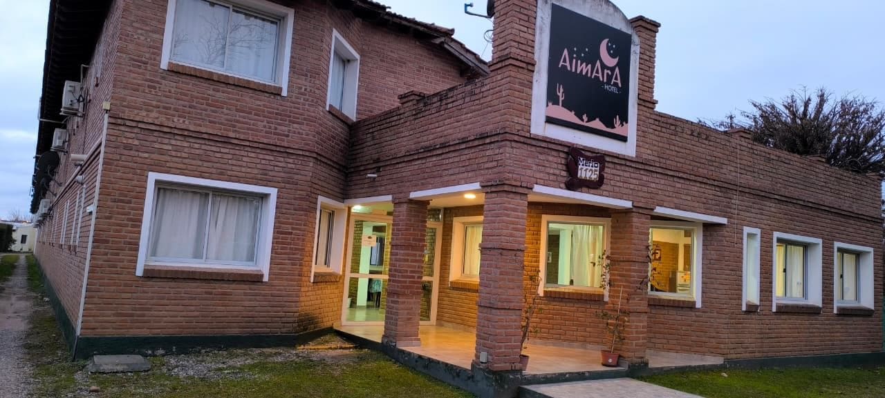 A brick building with a sign that reads 'AimaRa Hotel.'