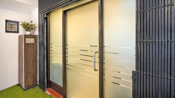 Una puerta moderna con un panel de vidrio esmerilado y un picaporte metálico.