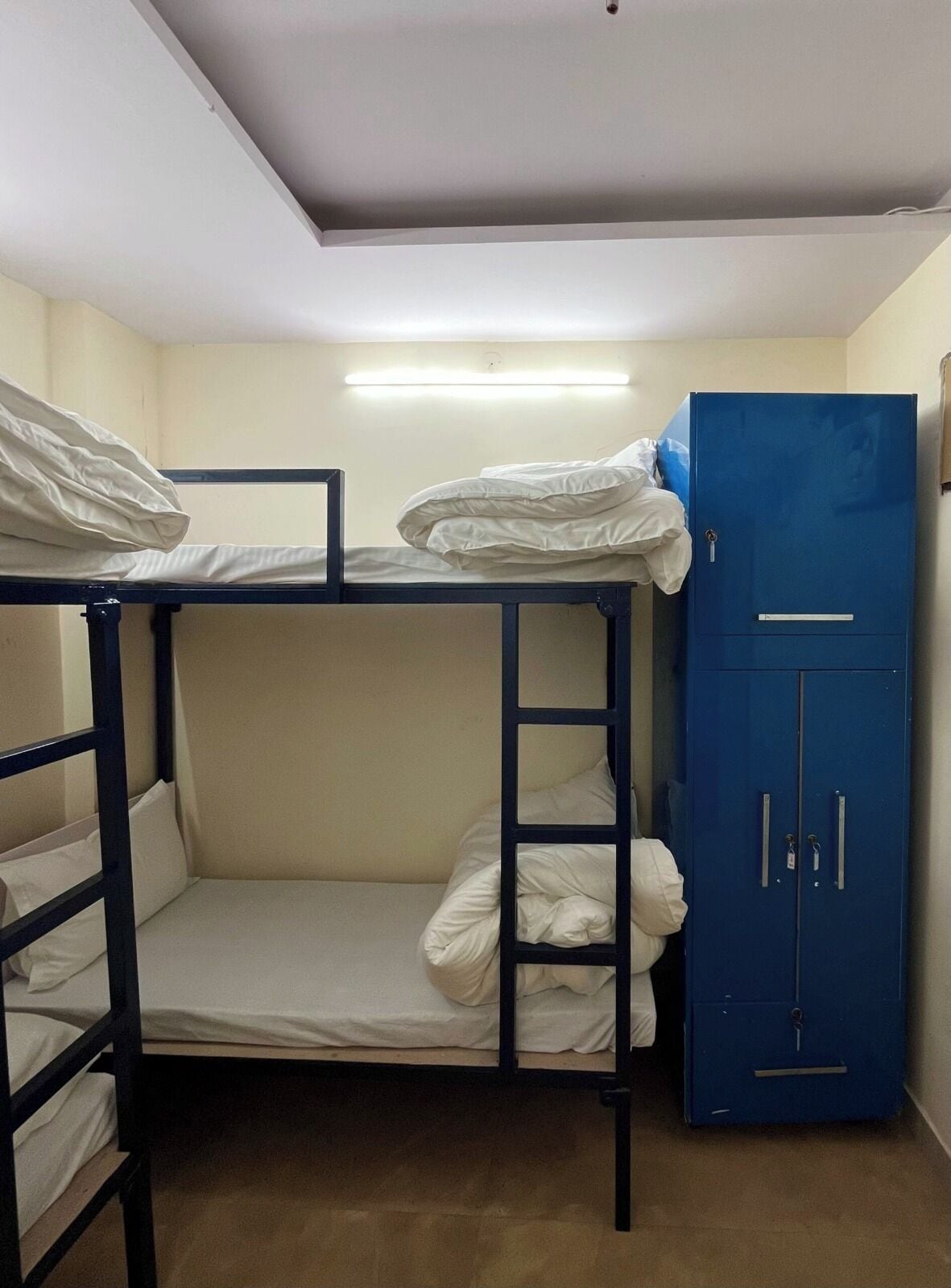 A bunk bed room with a blue wardrobe and a single bed.
