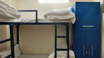 Een slaapkamer met een stapelbed, een blauwe garderobe en een enkel bed.