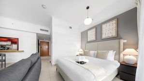 Ein Hotelzimmer mit Bett, Nachttischlampen, Schreibtisch mit Stuhl und einer Sitzecke.