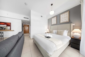 Ein Hotelzimmer mit Bett, Nachttischlampen, Schreibtisch mit Stuhl und einer Sitzecke.