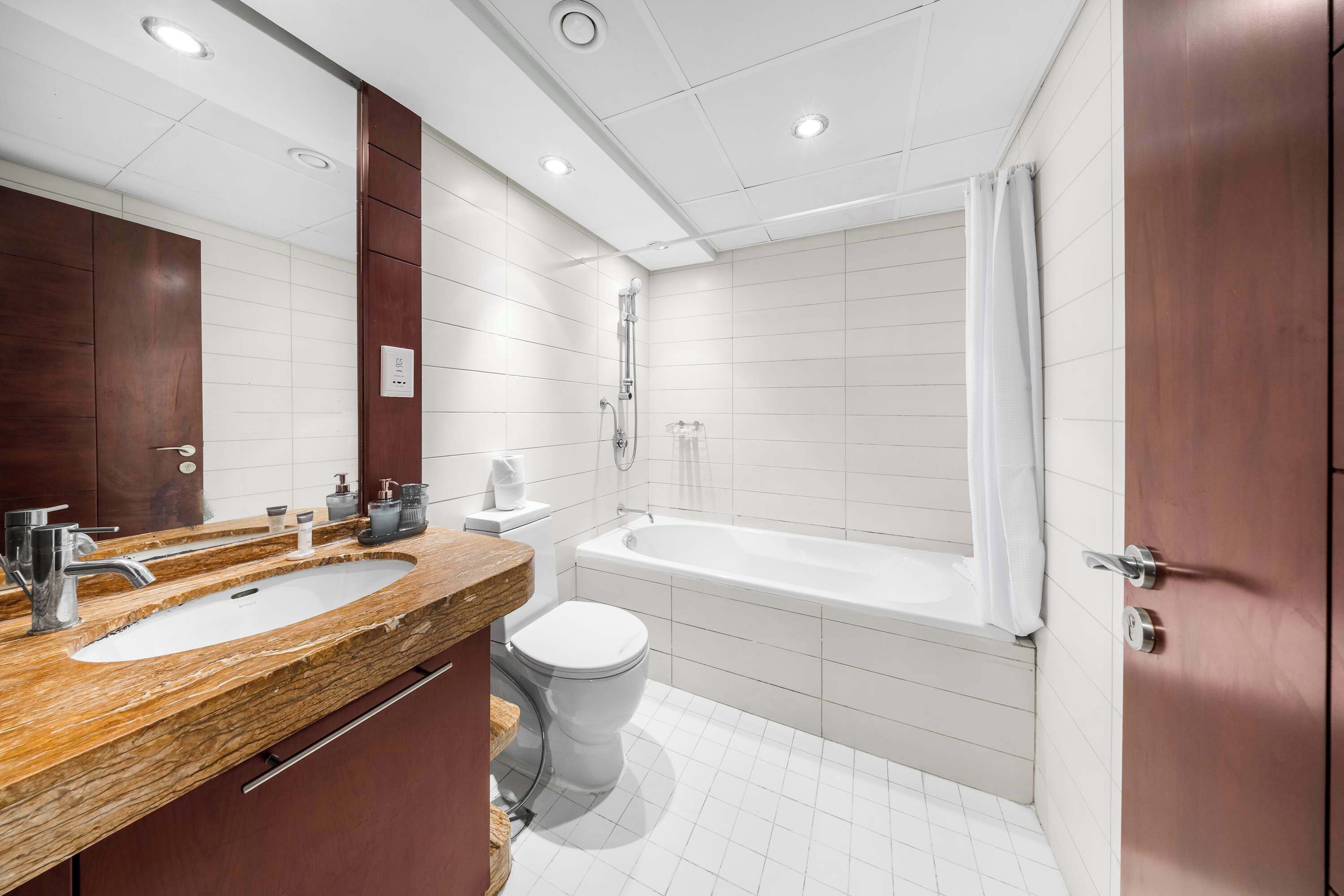 Ein modernes Badezimmer mit einem Doppelwaschtisch, einer Toilette und einer Badewanne.
