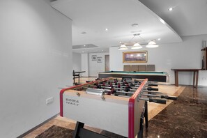 A modern indoor space with a foosball table labeled "ROMA ITALY" and a pool table. - StayShort - Luxury Studio Apartment in Downtown with Balcony (Downtown)