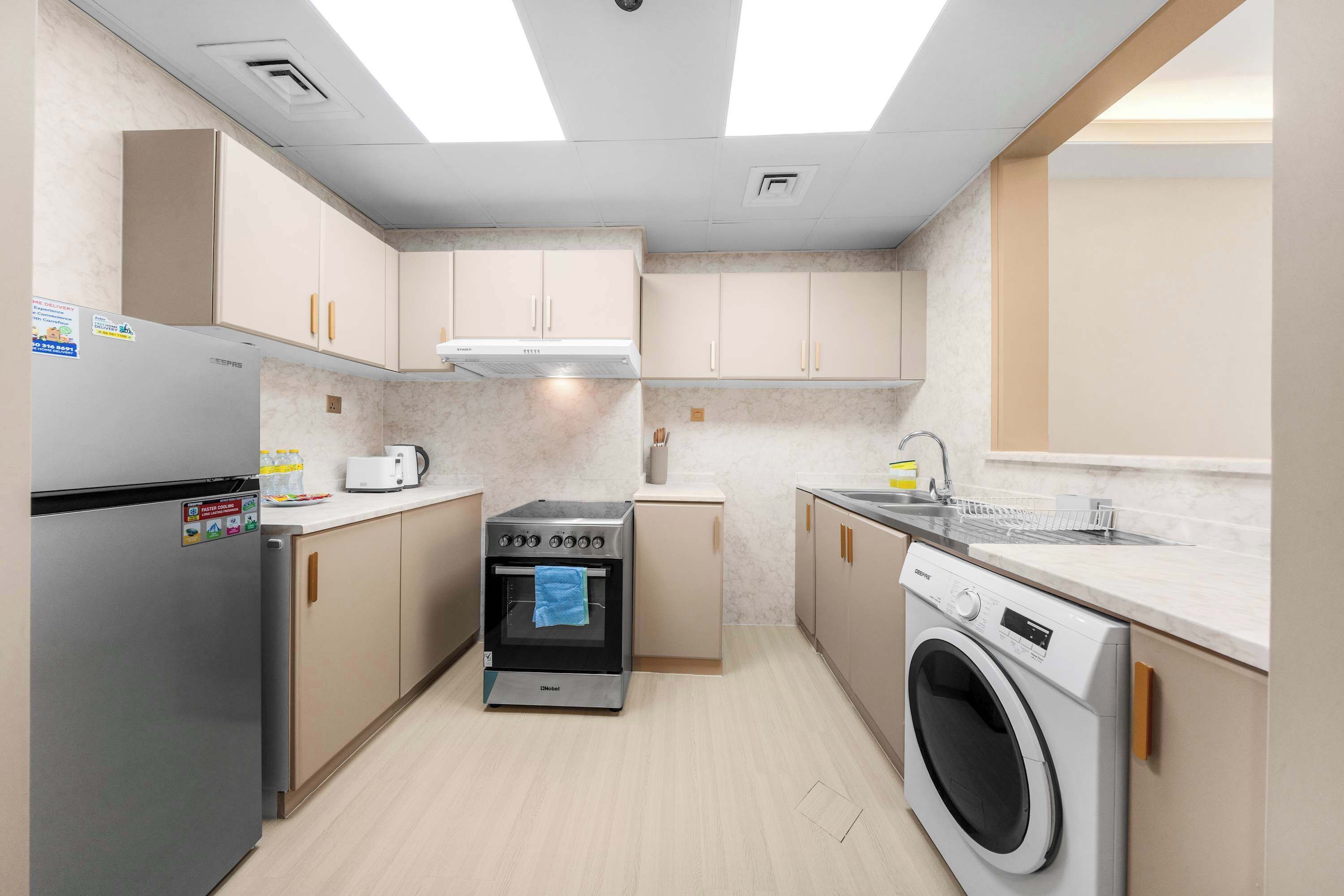 Una cocina compacta con horno integrado, lavadora y lavaplatos.