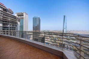A high-rise building with multiple floors, a clear sky, and a cityscape in the background. - StayShort - Cozy 2BR Apartment in JLT that Sleeps 4! (JLT)