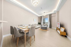 Un espace repas moderne avec une table en bois dressée pour quatre personnes, entourée de chaises rembourrées.
