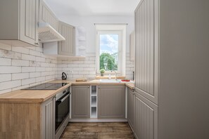 A compact kitchen with a window, a built-in oven, and a sink. - Lumina Family 4-room Apart near Metro  (Warszawa)