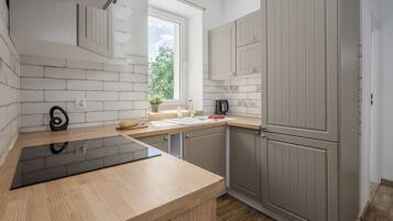 A modern kitchen with a wooden countertop, a built-in oven, and grey cabinets.