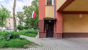 En byggnadsingång med en dörr, en flagga och en skylt som förbjuder parkering.