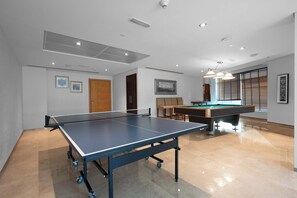Una estada àmplia amb taula de ping-pong, taula de bitlles i taula de billar.