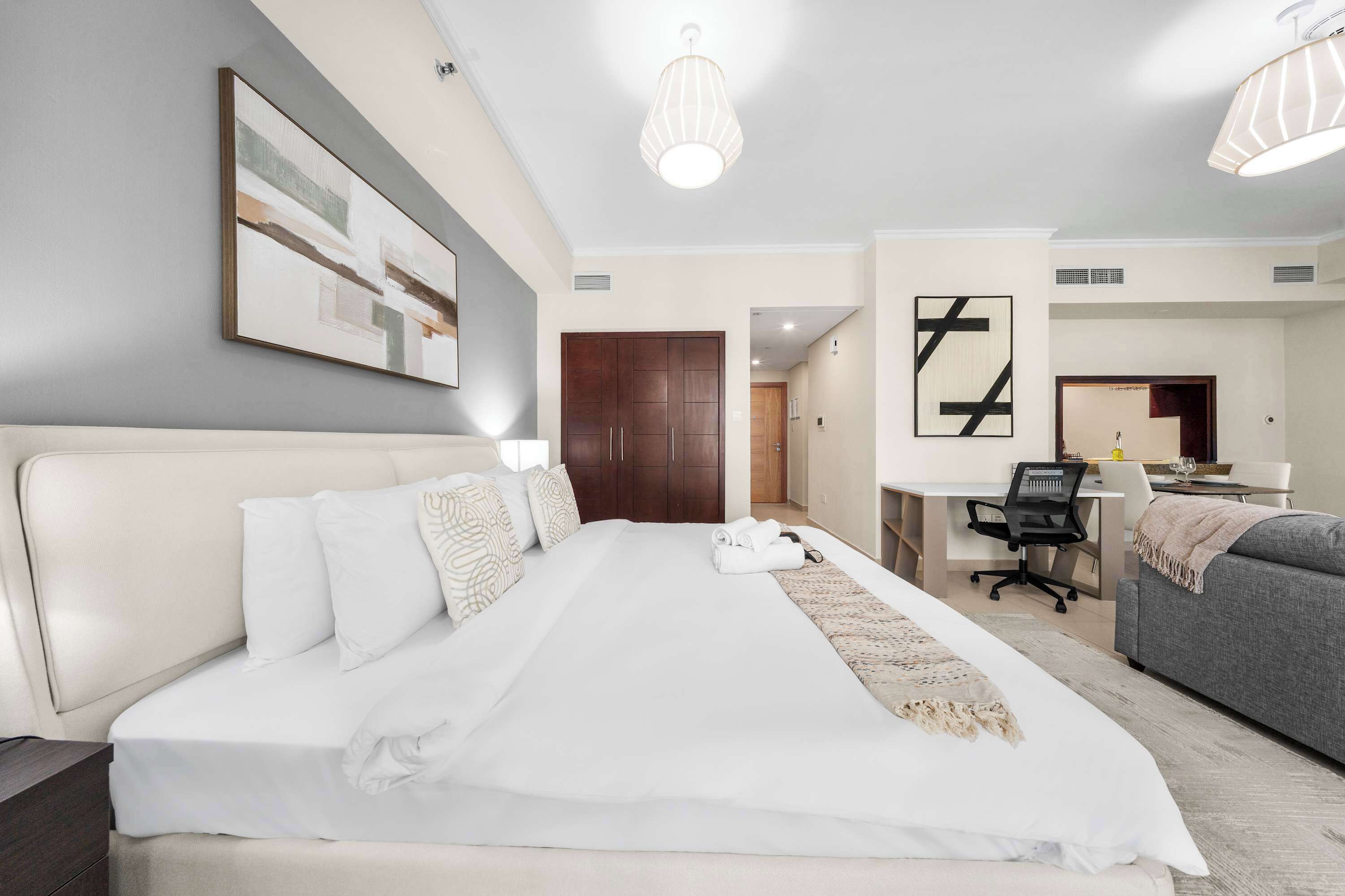 Een moderne hotelkamer met een groot bed, een bureau en een bank.