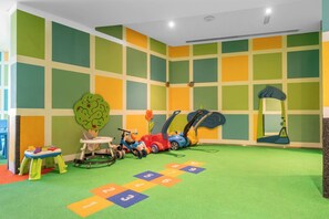 A children's playroom with colorful walls, a play mat with numbers, and various toys. - StayShort - Modern and Chic Studio in Downtown with Burj Khalifa Views! (Downtown)