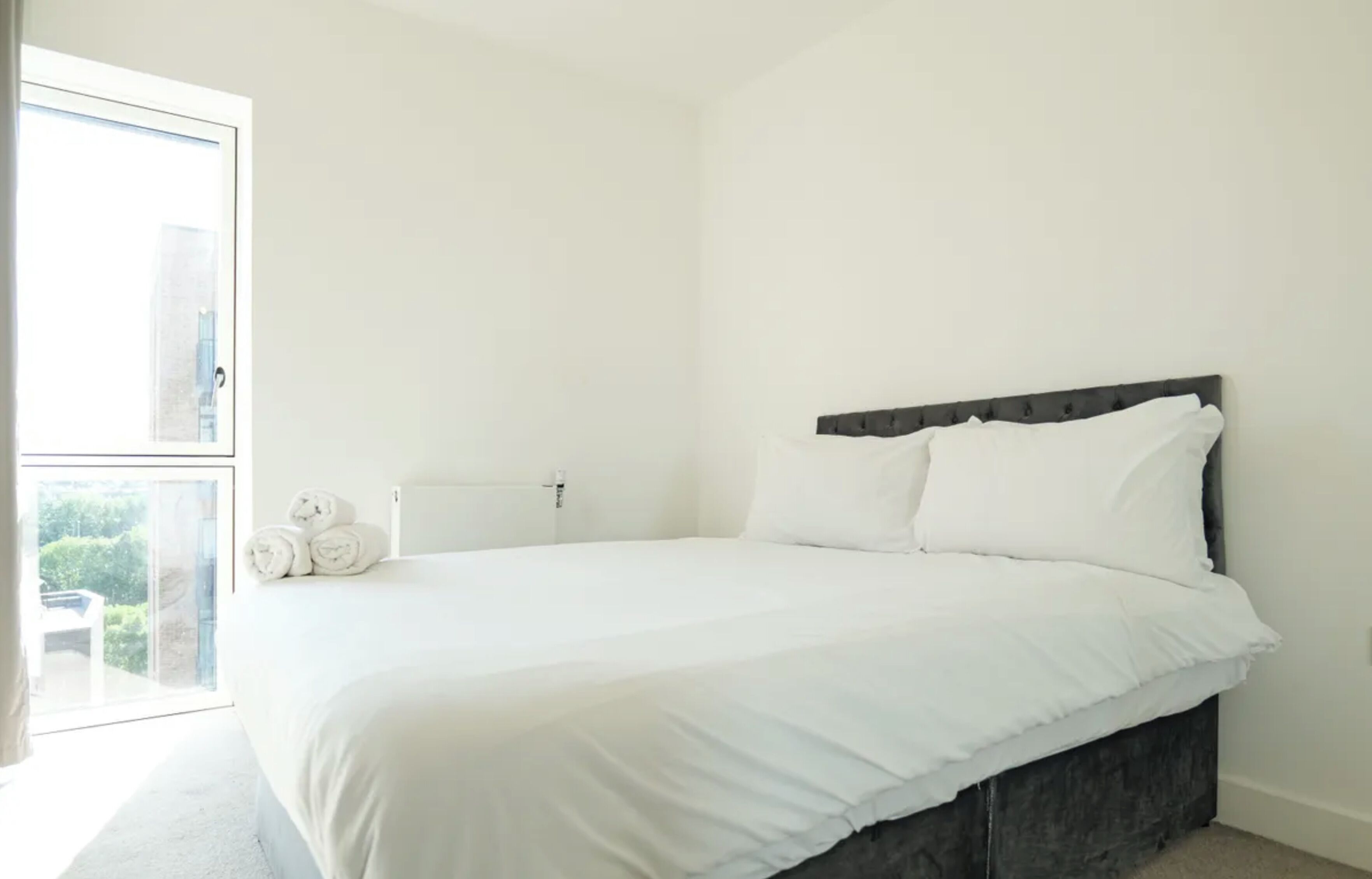 Una camera da letto con un letto grande, una finestra e vista sul verde.