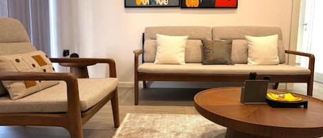 Un salon avec un canapé, un fauteuil et une table basse.