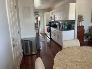 A kitchen with white cabinets, a stainless steel refrigerator, and a microwave. - Backyard Oasis with Fire Pit, Grill & Outdoor TV, 15 Min to La Jolla (San Diego)