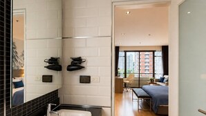Ein modernes Badezimmer mit einem weißen Waschbecken, einer schwarzen Arbeitsplatte und einem Spiegel.