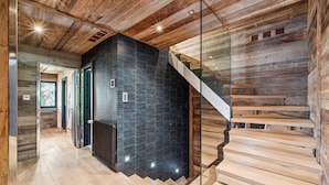 A modern interior with a wooden staircase and a glass railing. - The Crest by Mrs Miggins ****Welcome to The Crest by Mrs Miggins ****, an exceptional chalet nestled (Crans-Montana)