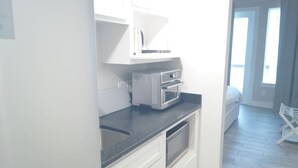A kitchen with a microwave, oven, and sink.