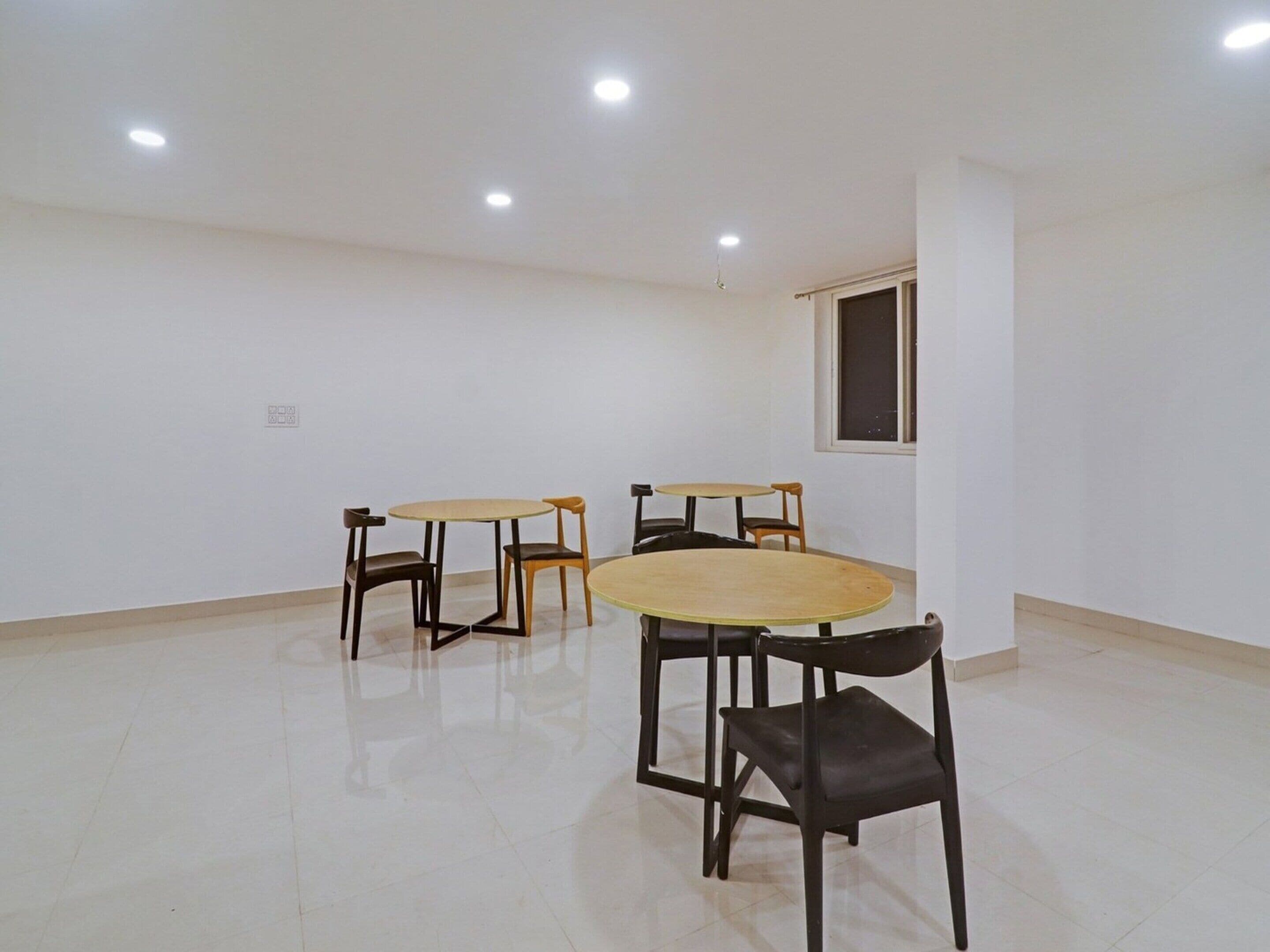 A room with a tiled floor, a window, and a table with chairs.